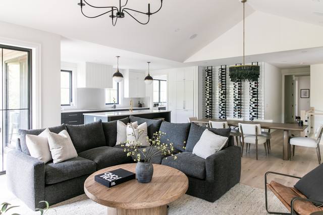 Bright great room under a vaulted ceiling, open to the kitchen and dining area
