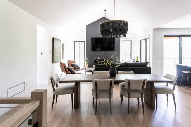 Great room under a vaulted ceiling with dining table
