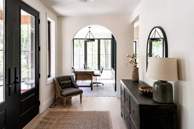 Bright front entry with an arched opening and wide-plank floors